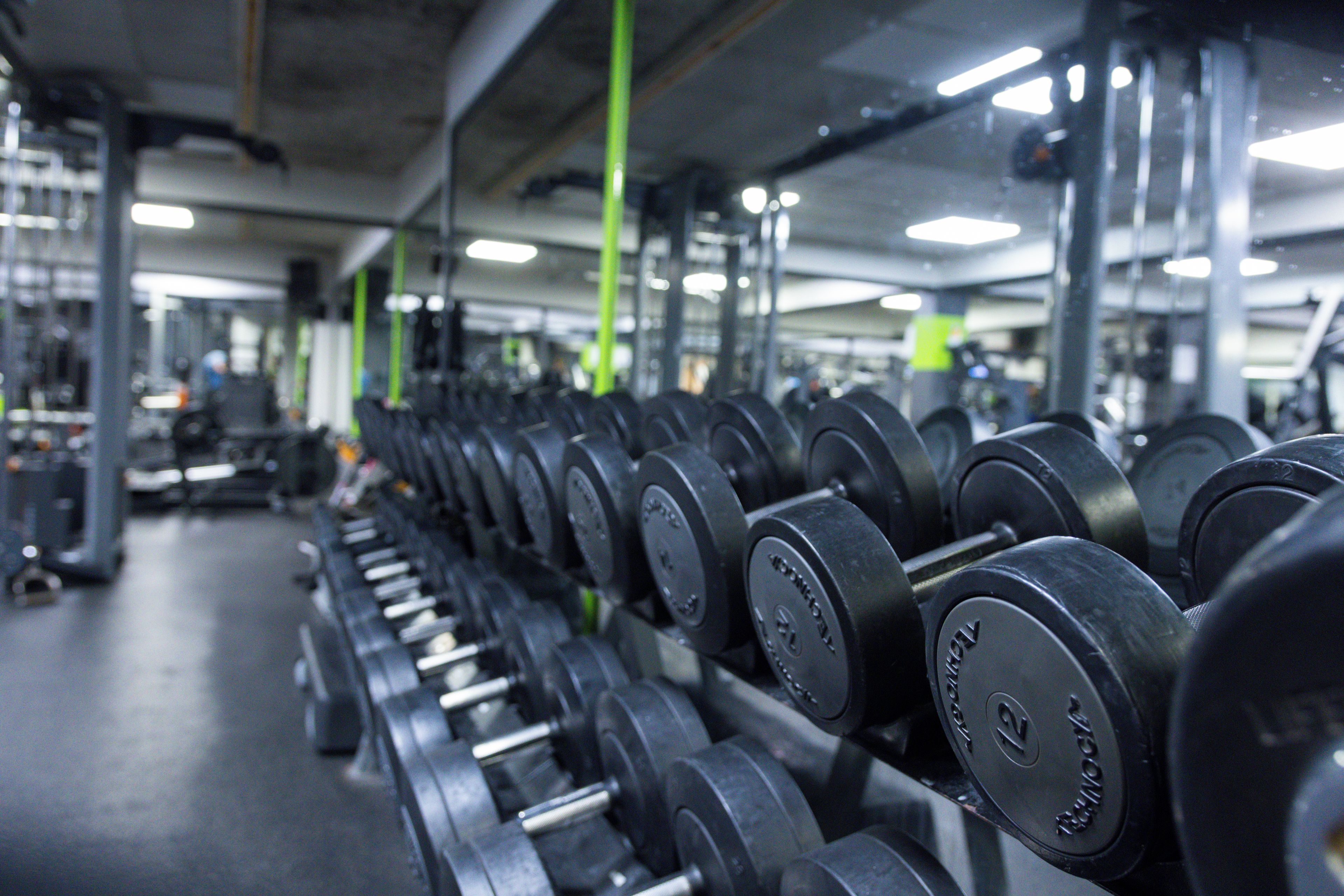 A gym with rows of dumbbells and exercise equipment.