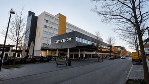 A CITYBOX building with a modern architectural design, a covered entrance, and a clear sky.