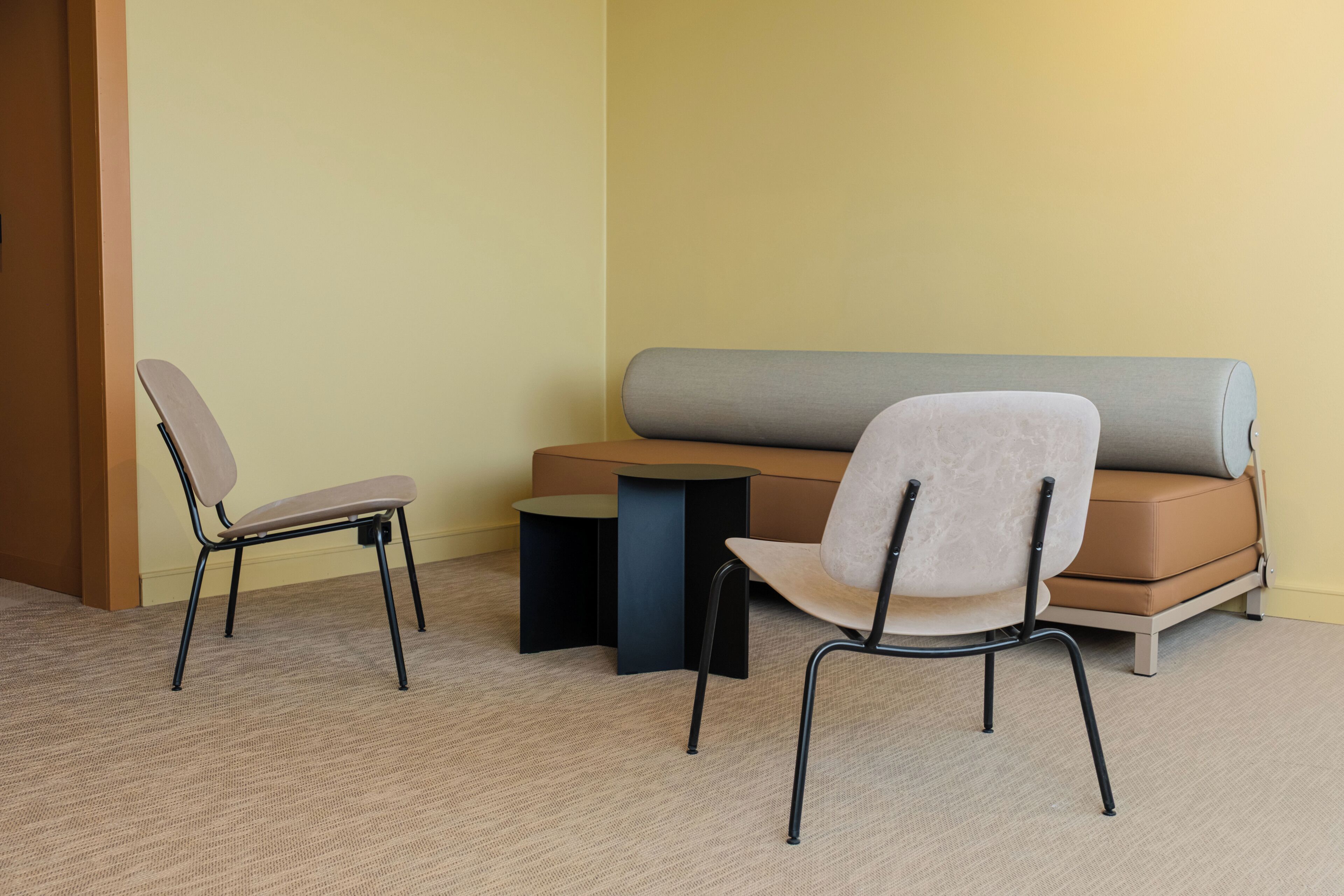 A room with a sofa, two chairs, and a small table.