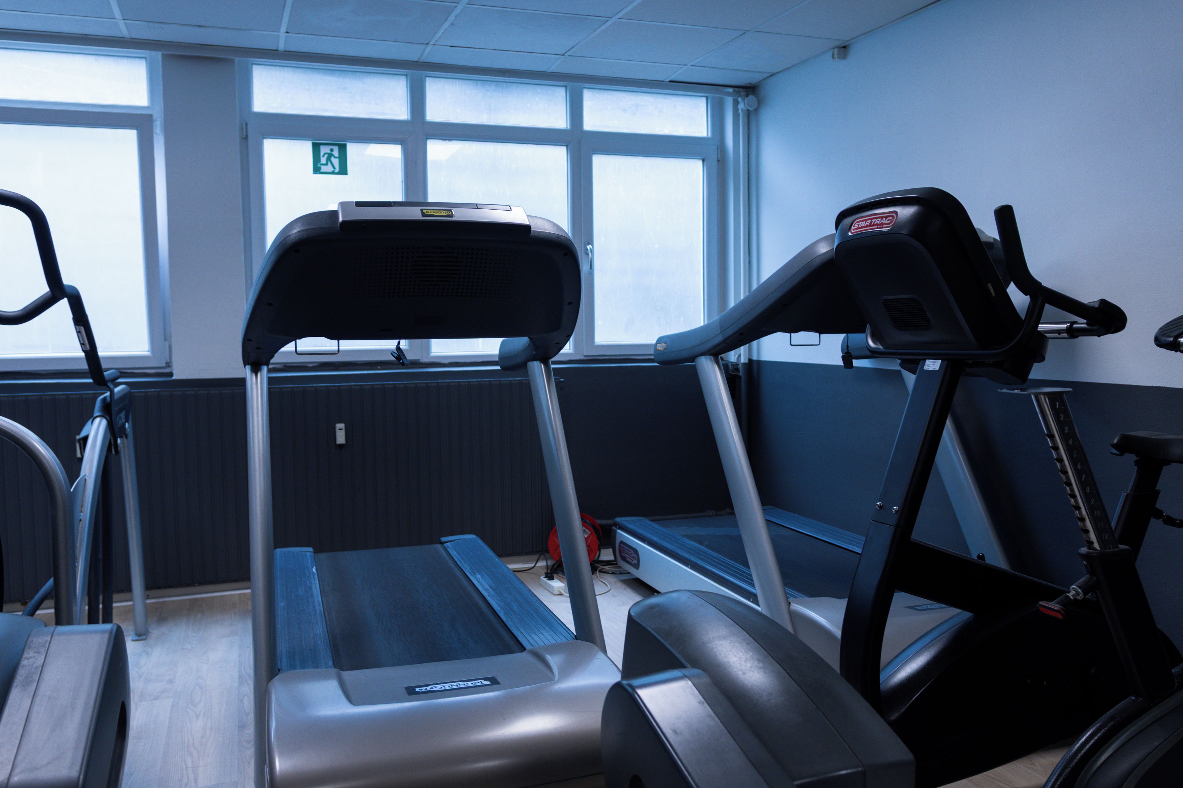 A gym with treadmills, stationary bikes, and a rowing machine.