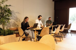 Moderni sisätila, jossa on istuimia ja pöytiä, ja joka soveltuu kokouksiin tai työskentelyyn.