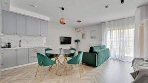 A modern living space with a dining area, kitchen, and seating area. - Nadmotławie C14 | Riverside | Sauna & Gym (Gdańsk)