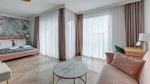 A modern hotel room with a bed, a round coffee table, and a sofa. - Nadmotławie C42 | Riverside | Sauna & Gym (Gdańsk)