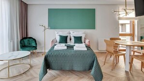 A hotel room with a bed, a round table, a chair, a desk, and a television. - Nadmotławie C42 | Riverside | Sauna & Gym (Gdańsk)