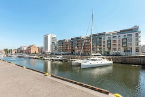 A marina with boats docked, a waterfront promenade, and modern buildings in the background. - Waterlane F13 | Spa, Pool & Gym | Riverside (Gdańsk)