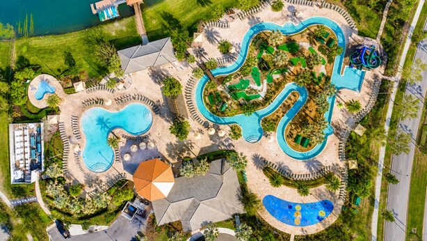 Vista aérea de un resort con varias piscinas, una zona de playa y una cancha de baloncesto.