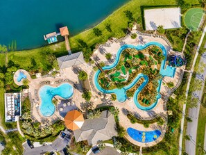 An aerial view of a resort with multiple swimming pools, a beach area, and a basketball court. - Townhome Close to Disney w Resort Pool (Kissimmee)