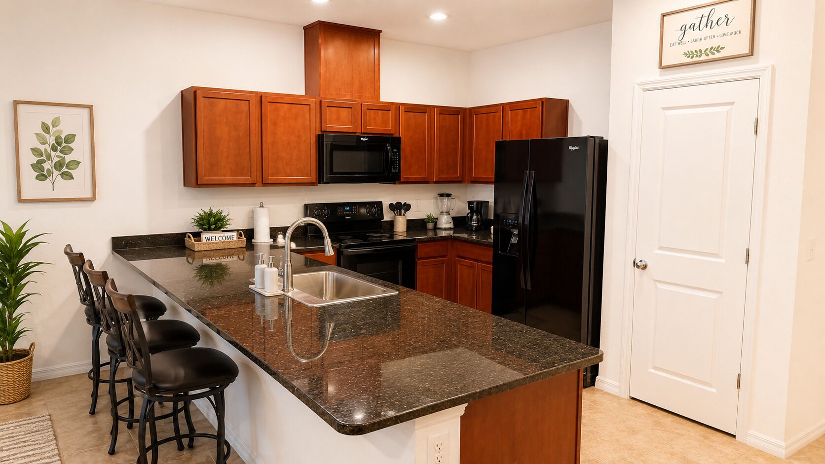 A kitchen with wooden cabinets, a black refrigerator, a microwave, and a granite countertop.