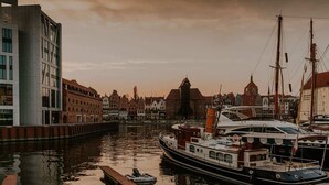 Kanava, jossa on veneitä, laituri ja historiallisia rakennuksia.