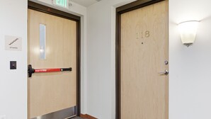 Two wooden doors with a push bar on the left, an exit sign above, and a stairway sign below. - Riverfront Retreat – 10 Mins to Lambeau! (Green Bay)