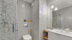 Un bagno moderno dotato di doccia, WC e lavabo.