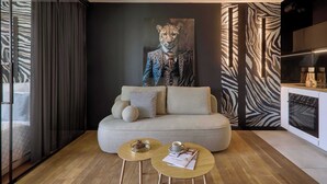 A modern living room with a sofa, two coffee tables, a zebra-patterned wall, and a large painting. - Vistula View - Riva Verona | Parking (Kraków)