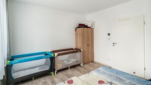 Una habitación con cuna, armario y puerta.