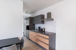Una cucina moderna con forno a incasso, macchina del caffè e bollitore sul piano di lavoro.