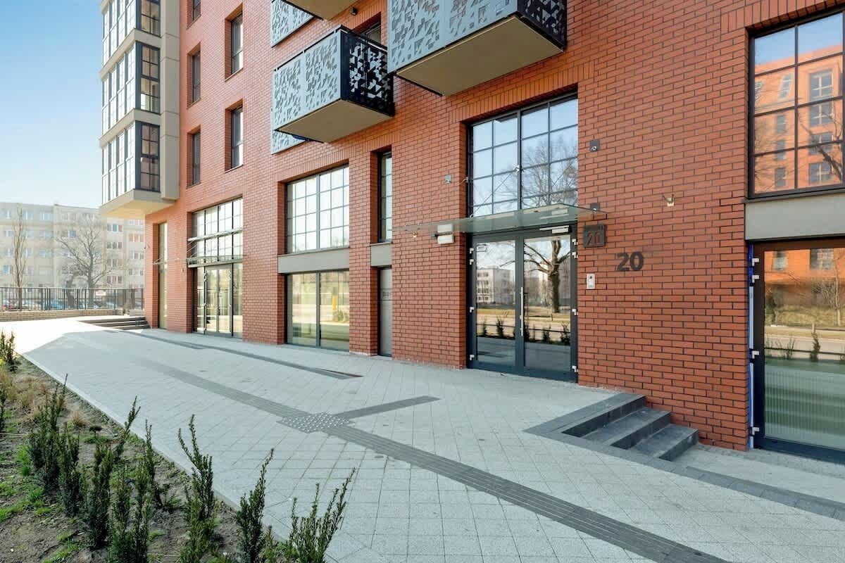 Ein modernes Gebäude mit großen Fenstern, einer Ziegelaußenwand und der Nummer 20.