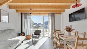 En moderne stue med sofa, spisebord med stole, fjernsyn og pejs.