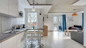 Una cocina moderna con comedor, sofá y vistas al exterior.