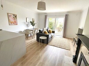 Un salon moderne avec un canapé, une table à manger et un ordinateur portable posé sur un bureau.
