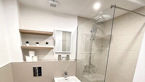 Un bagno moderno con un WC, un lavandino e una doccia.