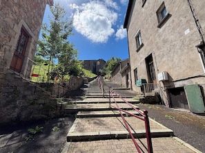 A narrow alleyway with stone buildings, a staircase, and a clear blue sky. - Getaway in Auvergne - Historic Center - 3 people (Olliergues)