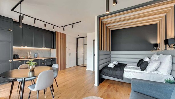 A modern living space with a dining area, a sofa, and a kitchen. - Nadmotławie B17A | Riverside & Gym (Gdańsk)