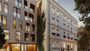 Een modern meerlaags gebouw met balkons, grote ramen en een etalage.