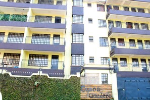 Un edificio de varios pisos con balcones, una entrada con reja y un letrero que dice 'Cijana Gardens'.