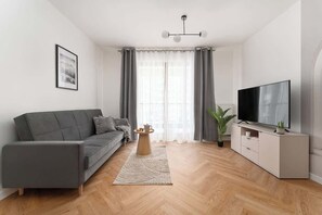 A modern living room with a sofa, TV, and a coffee table. - Towarowa Square | Balcony & Parking (Warszawa)