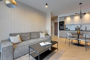 Ein modernes Wohnzimmer mit einer Couch, einem Couchtisch und einem Essbereich mit Stühlen.