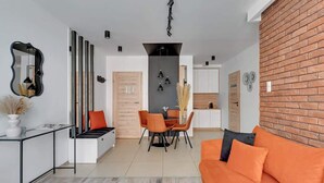 Un salon moderne comprenant un canapé, un coin repas et une cuisine.