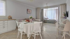 Una habitación moderna y luminosa con una mesa de comedor, sillas, un sofá y una cama con vistas.