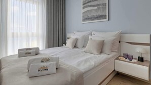 Una habitación de hotel con una cama, una mesita de noche, una lámpara y un cuadro en la pared.
