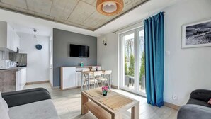 Una sala de estar moderna con un sofá, una mesa de centro de madera y un comedor con mesa y sillas.