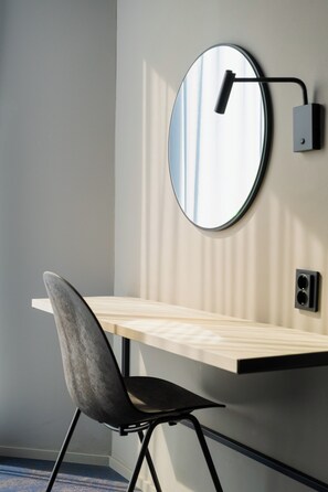 A modern room with a round mirror on the wall, a wooden desk, and a black chair. - Citybox Tromsø (Tromsø)