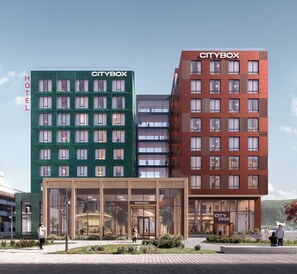 Et moderne hotel med flere CITYBOX-bygninger, store vinduer og et velholdt udendørs område.