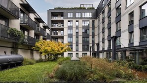 A modern apartment building with balconies, a central courtyard, and a visible water tank. - Wawrzyńca 59 | Perfect for Families (Kraków)