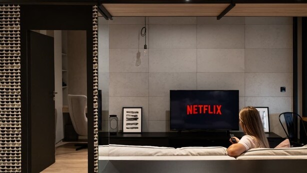 A modern living room with a sofa, a television displaying 'NETFLIX,' and a coffee table. - Wawrzyńca 59 | Perfect for Families (Kraków)