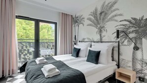 A hotel room with a bed, a nightstand, a lamp, a window with curtains, and a wall mural. - Dwie Motławy 30 | River View | City Center (Gdańsk)