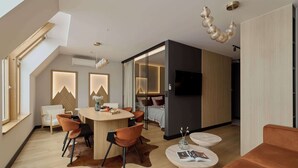 Ein modernes Interieur mit Essbereich, einer Couch und einem Fernseher in einem Schlafzimmer.