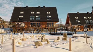 Ein Hotel mit dunklem Dach, zahlreichen Fenstern und einer Holzfassade.