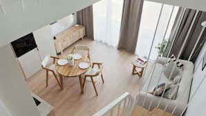 En modern lägenhet med matplats, soffa och kök.