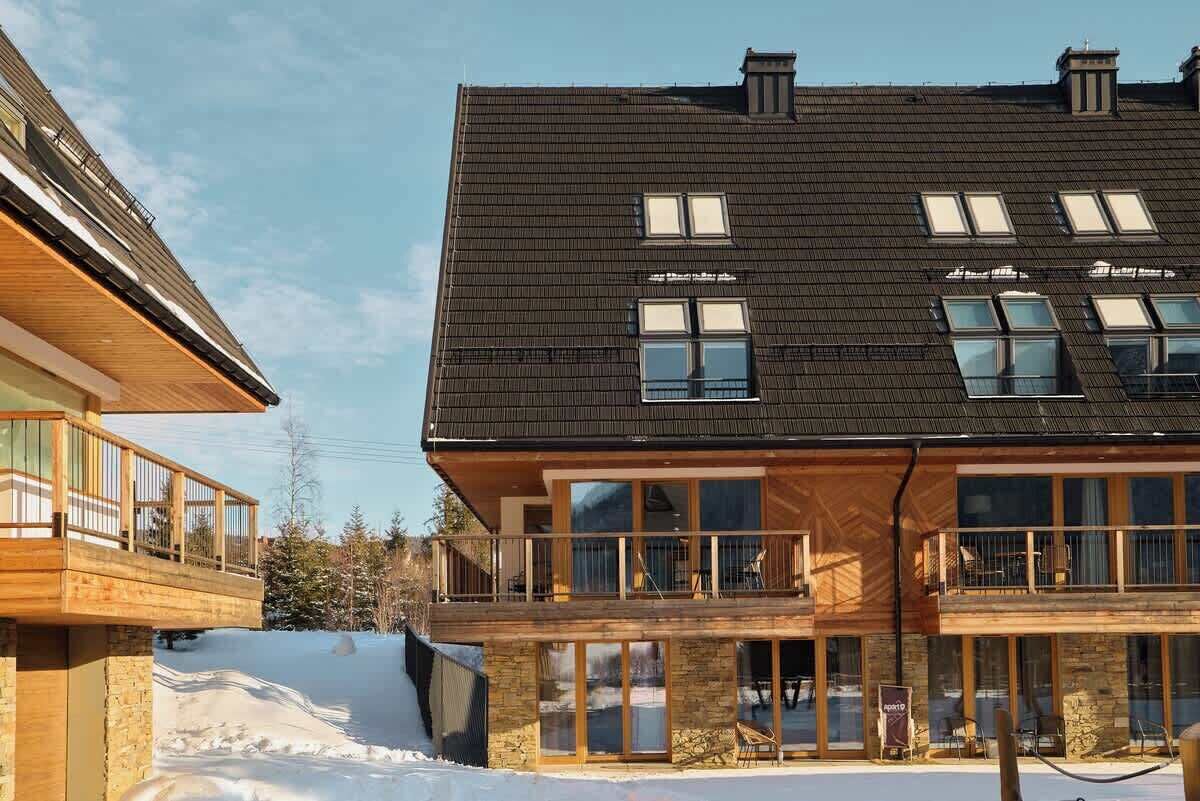 Un immeuble à plusieurs étages, doté de grandes fenêtres, de balcons et d’une façade en pierre.