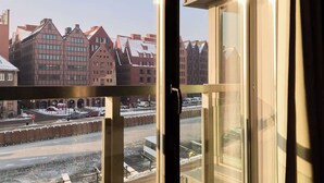 Blick aus einem Fenster auf eine Straße mit Gebäuden, einer Brücke und einem Fluss.