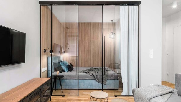 A modern bedroom with a bed, a TV, a desk, and a chair. - Nº23 | Pool, SPA & Gym (Gdańsk)