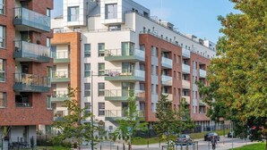 Un edificio residenziale a più piani con balconi, una strada pavimentata e un percorso pedonale.