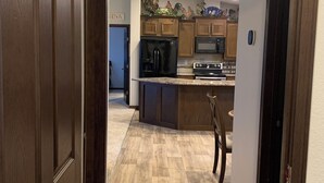 A kitchen with wooden cabinets, a refrigerator, an oven, and a microwave. - Spacious 4-bedroom house in charming rural Powell with media and fitness room (Powell)
