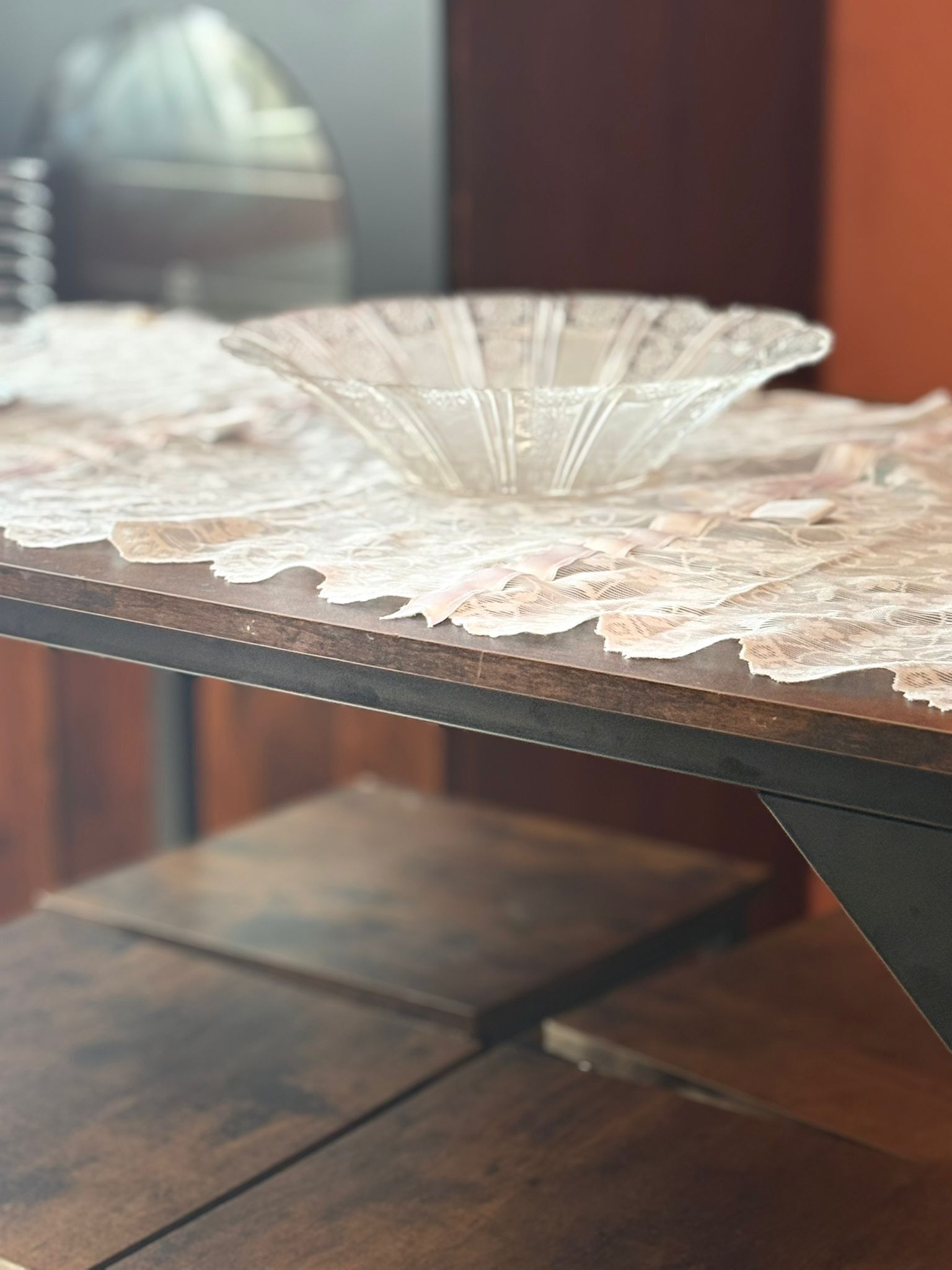 A table with a lace tablecloth and a wooden table.