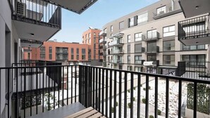 Un edificio residencial de varios pisos con balcones, un patio interior y una combinación de arquitectura moderna y tradicional.