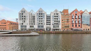 Et hotel ved vandet med moderne arkitektur, en dok og en sti for fodgængere.