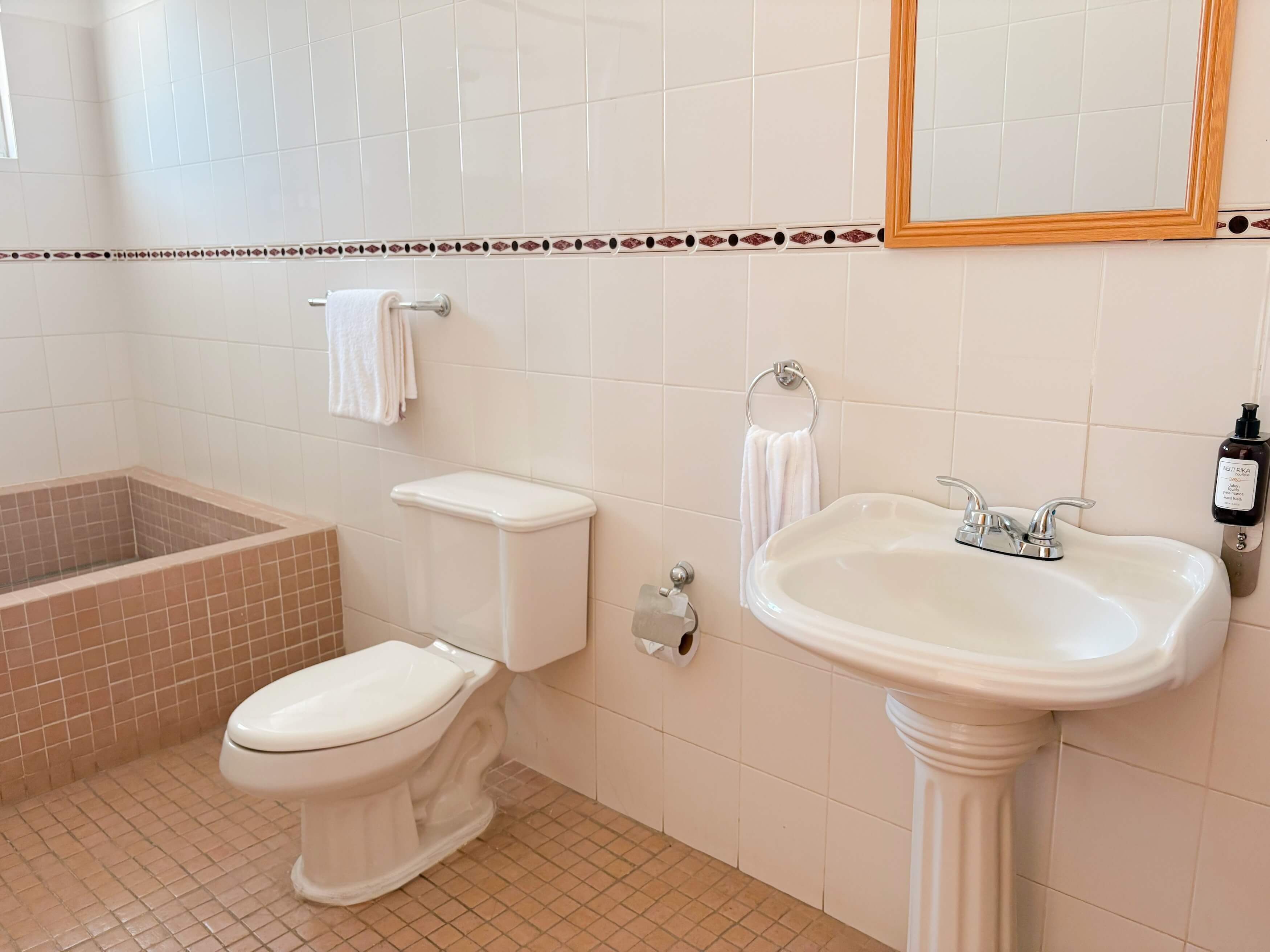 Une salle de bain avec des toilettes, un lavabo et une baignoire.